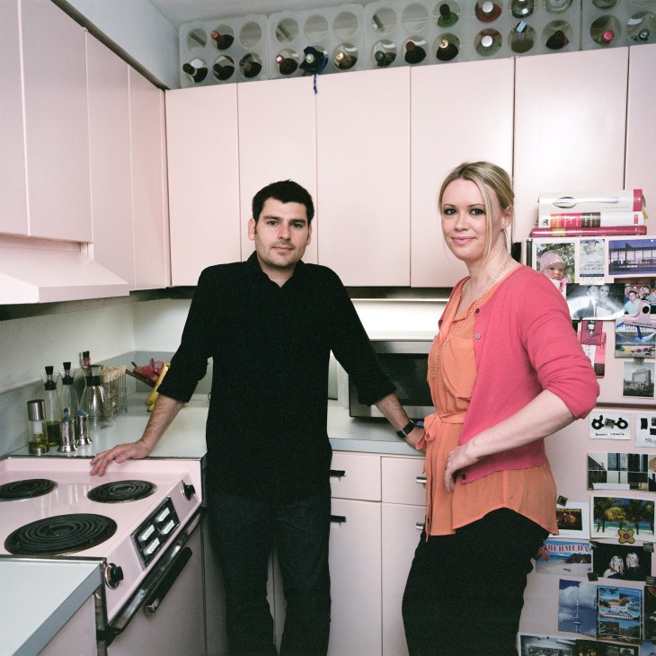 Iker and Julie Gil stand in their Marina City kitchen with original pink GE appliances and cabinetry.