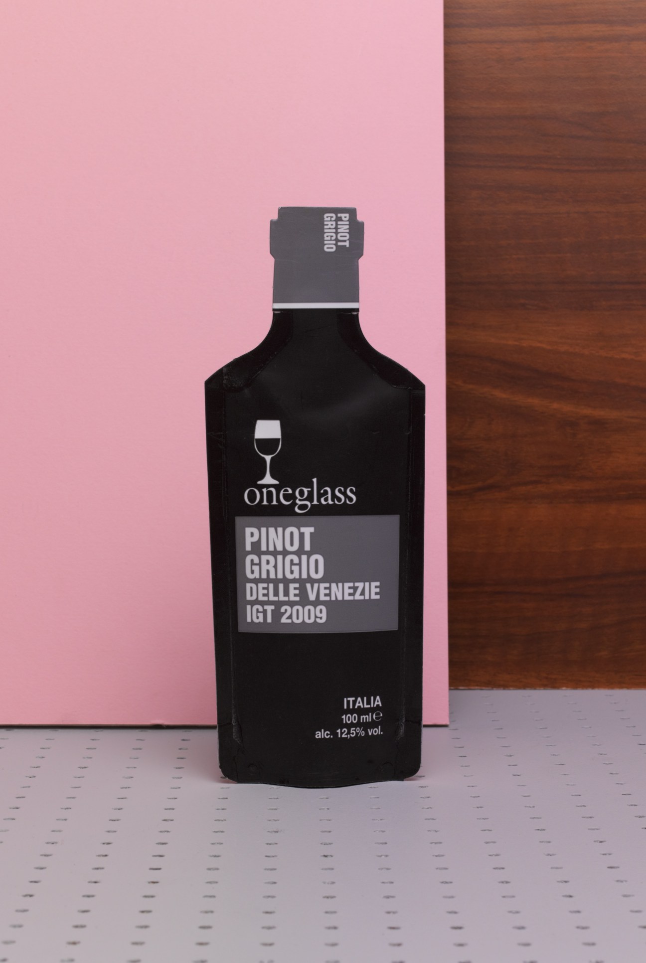 Oneglass Pinot Grigio Delle Venezie 100ml wine bottle against pink background
