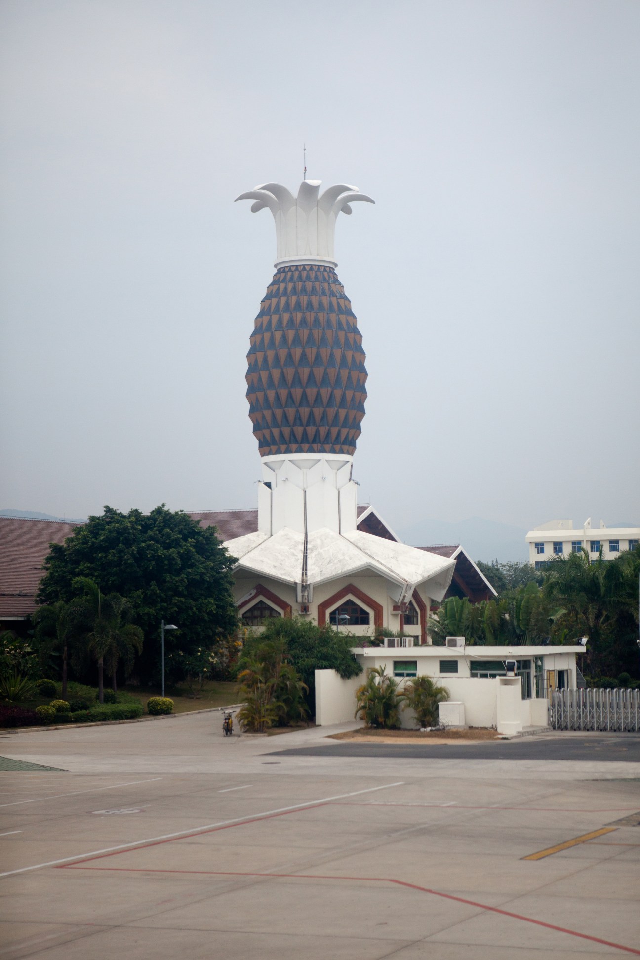 A distinctive pineapple-shaped structure with blue patterned body and white crown at Sanya Phoenix International Airport.