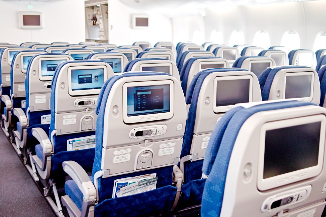 Korean Air A380 economy class cabin with blue and cream seats featuring individual entertainment screens.