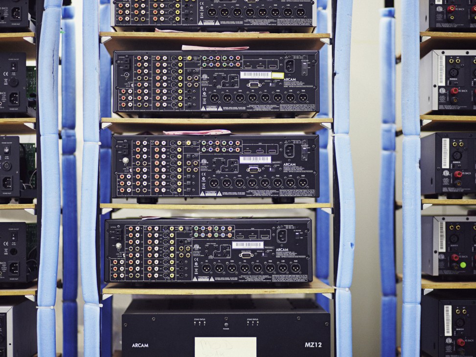 Stacked Arcam AV receivers showing multiple audio inputs and connectors with gold and white ports.