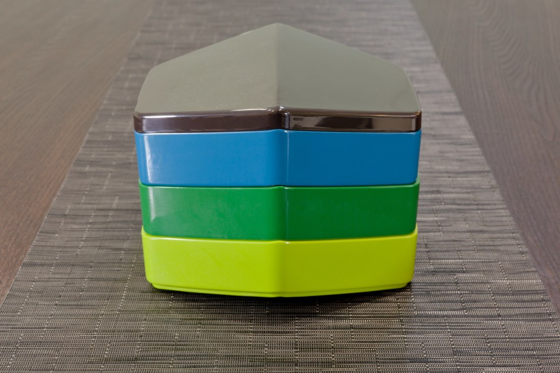 Stacked colorful container with cream lid, blue, green and lime-yellow layers and chrome band.