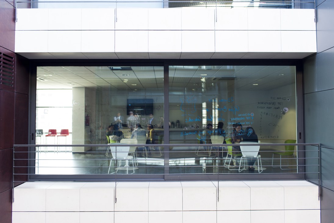 Madrid Emprende shared workspace with glass windows, white signage, and entrepreneurs working inside at modern desks.