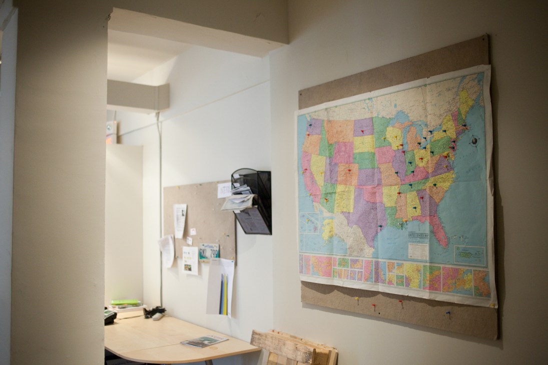 A colorful US map with pinned locations marking upcoming events on an office wall.
