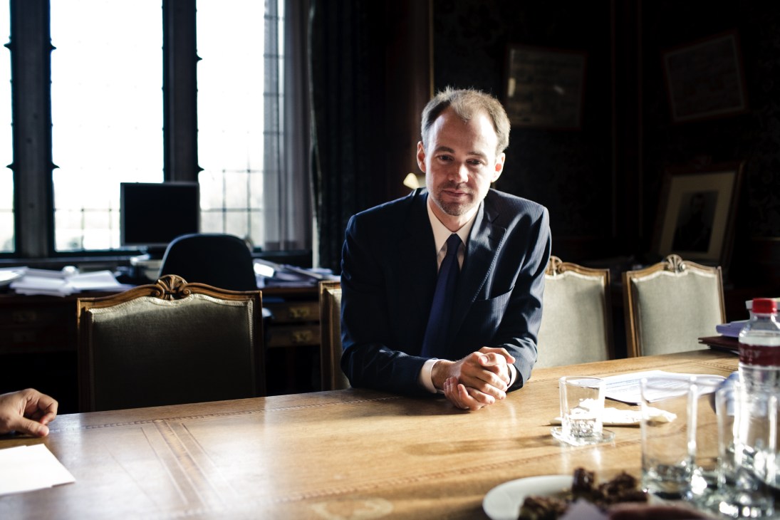 Deputy secretary-general Brooks Daly seated at a wooden conference table in an ornate office with tall windows behind him.