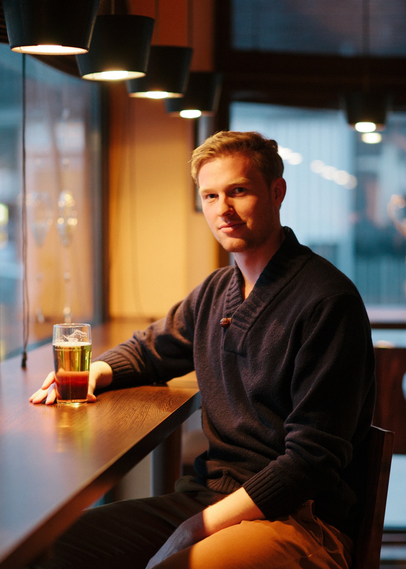 Journalist Torjus Kandal sits at a bar with a drink, looking at the camera.