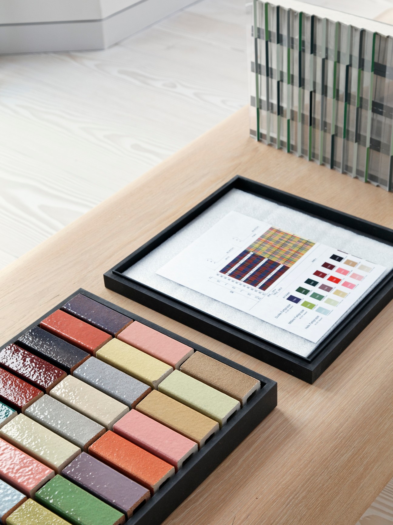 Ceramic façade samples and design documentation for Museum Brandhorst displayed on a wooden desk.