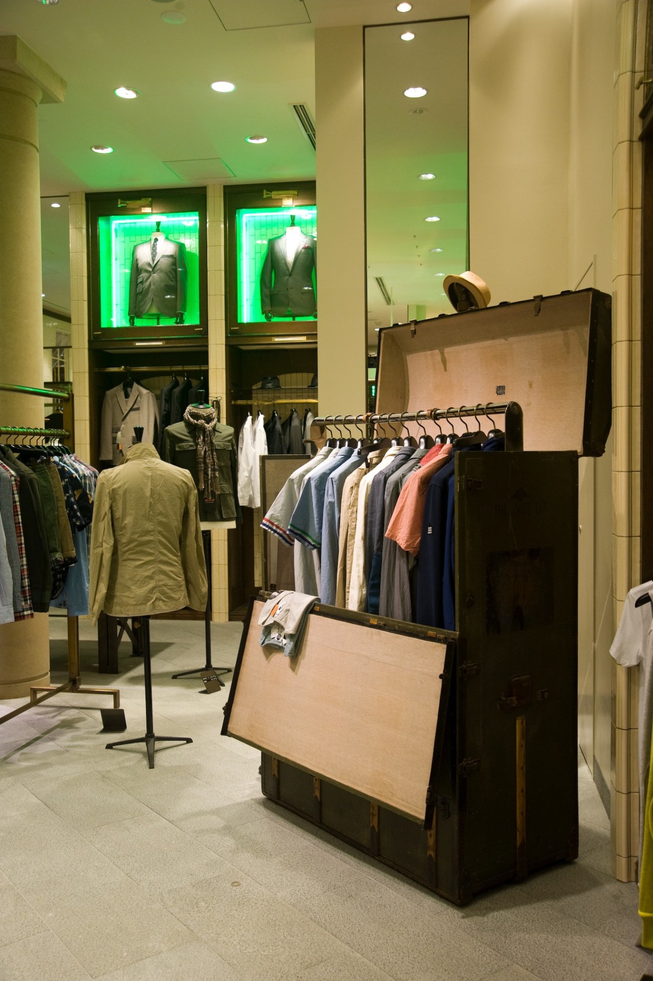 Interior of United Arrows retail store in Harajuku, Tokyo, featuring clothing displays, green neon-lit windows, and minimalist fixtures.