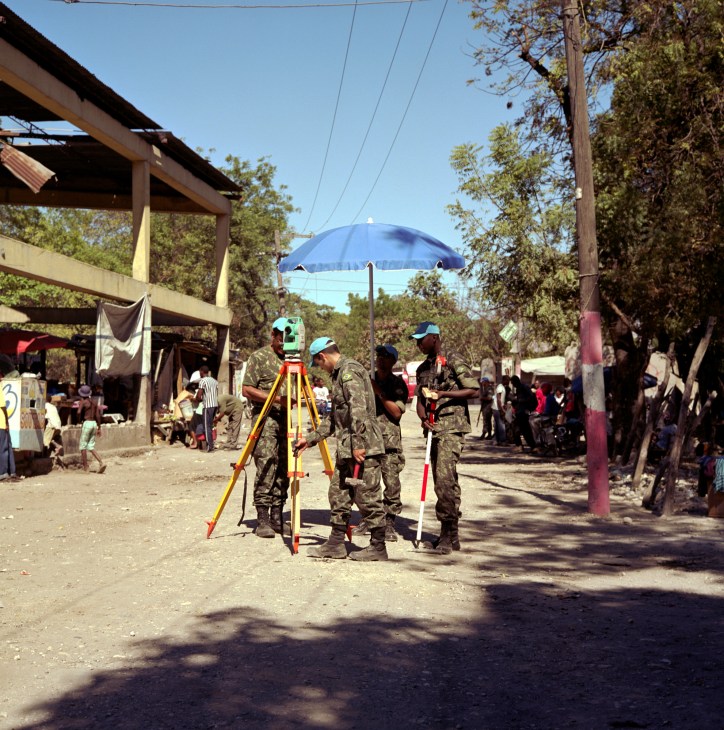 Brazilian military engineers survey a road with surveying equipment in Croix-des-Bouquets, Haiti.