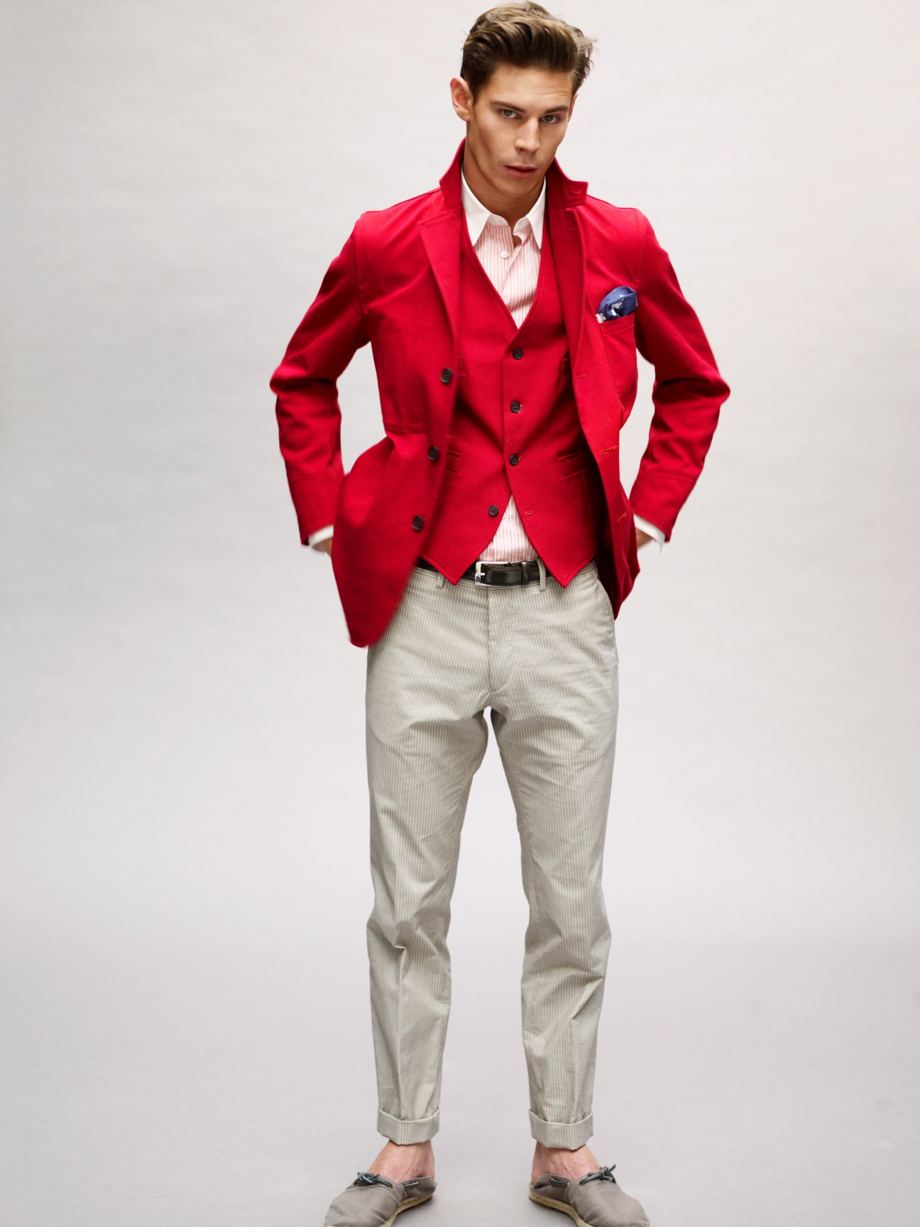 Model wearing red double-breasted Barena jacket and waistcoat with cream trousers and Hermès espadrilles.
