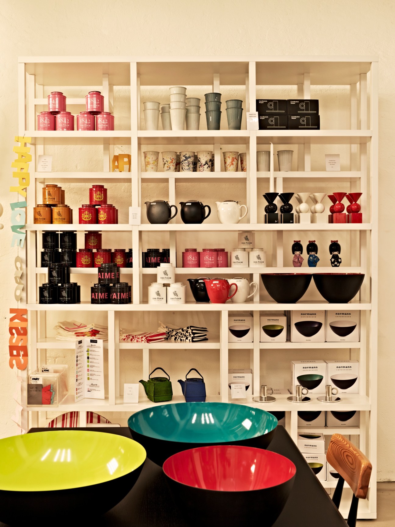 Krenit bowls by Normann Copenhagen displayed on shelves with home goods and design products.