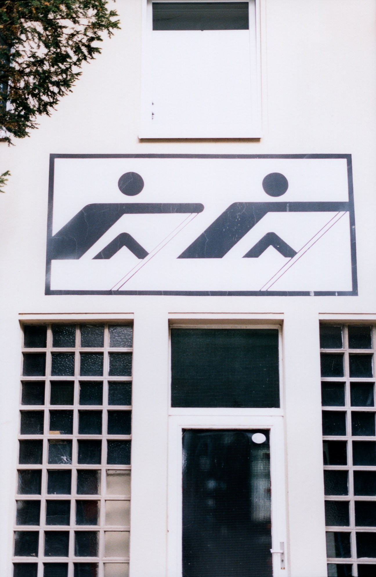 Modernist building facade with geometric rowing club logo featuring two stylized figures in a boat design.