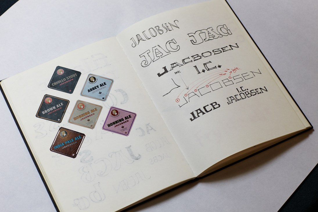 An open sketchbook showing hand-drawn font letterforms and beer label designs by Jonas Hecksher.