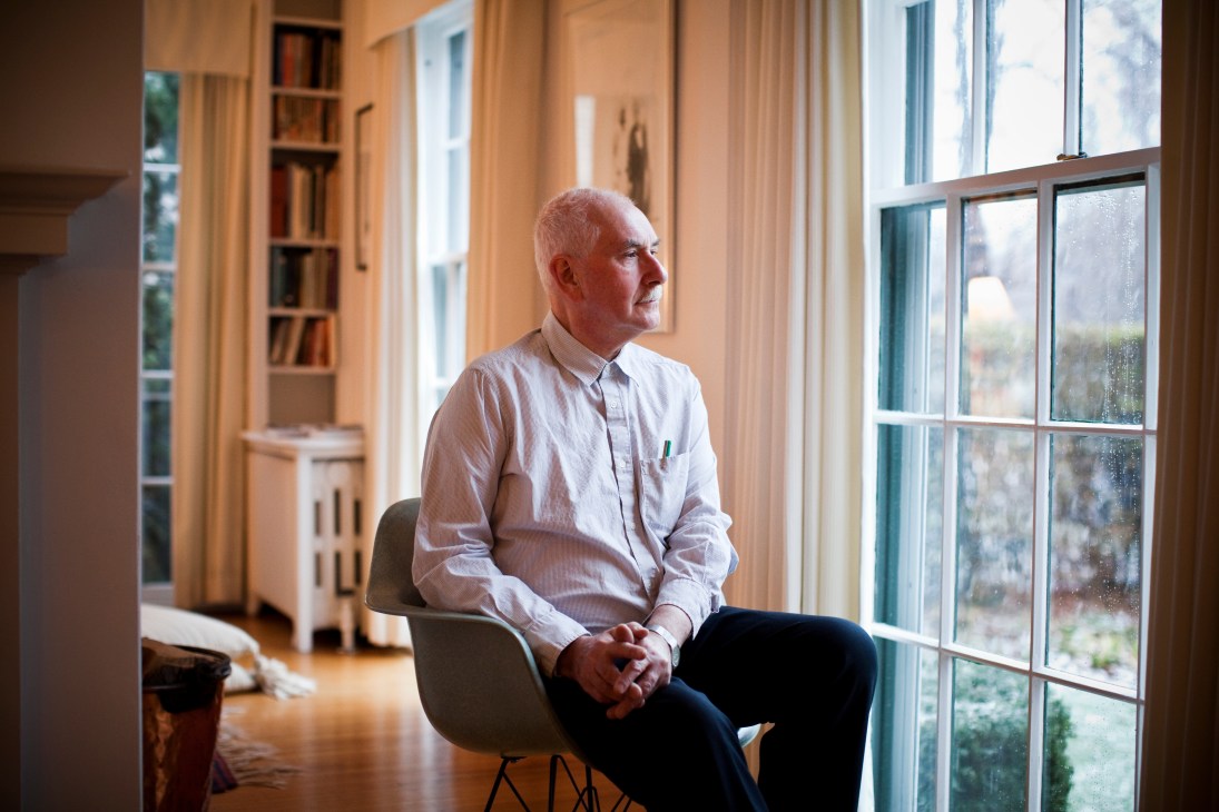 Brian Carter, dean of University of Buffalo's Architecture and Planning School, sits in a sunlit room with built-in bookshelves.