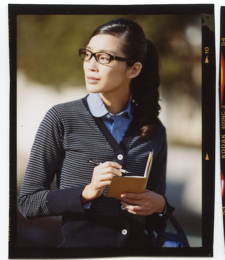 Model wearing Black Fleece cardigan and Engineered Garments shirt holds a Valextra notebook while wearing Four Nines glasses.