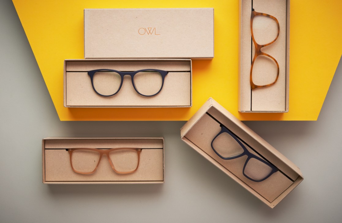 Owl eyewear brand handmade acetate frames displayed in packaging against yellow background.