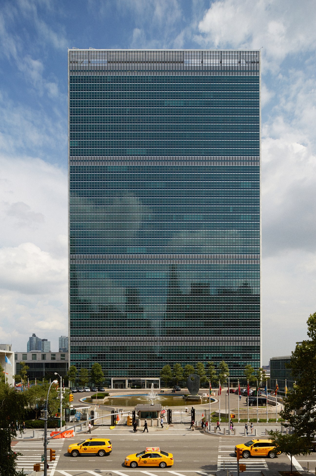 The 38-story United Nations headquarters building in New York with glass facade and plaza below.