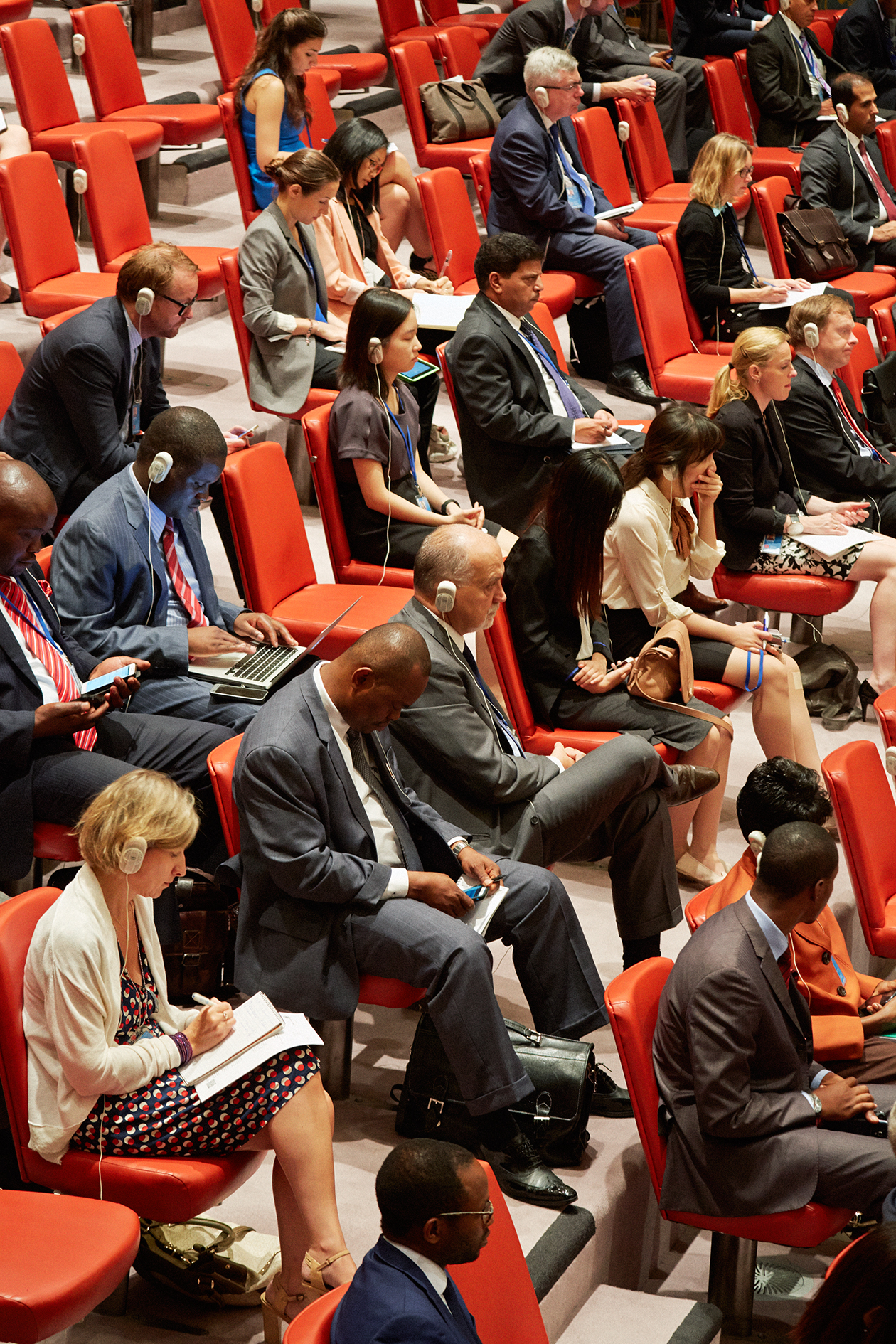 UN delegates seated in red chairs during a Security Council session observation.