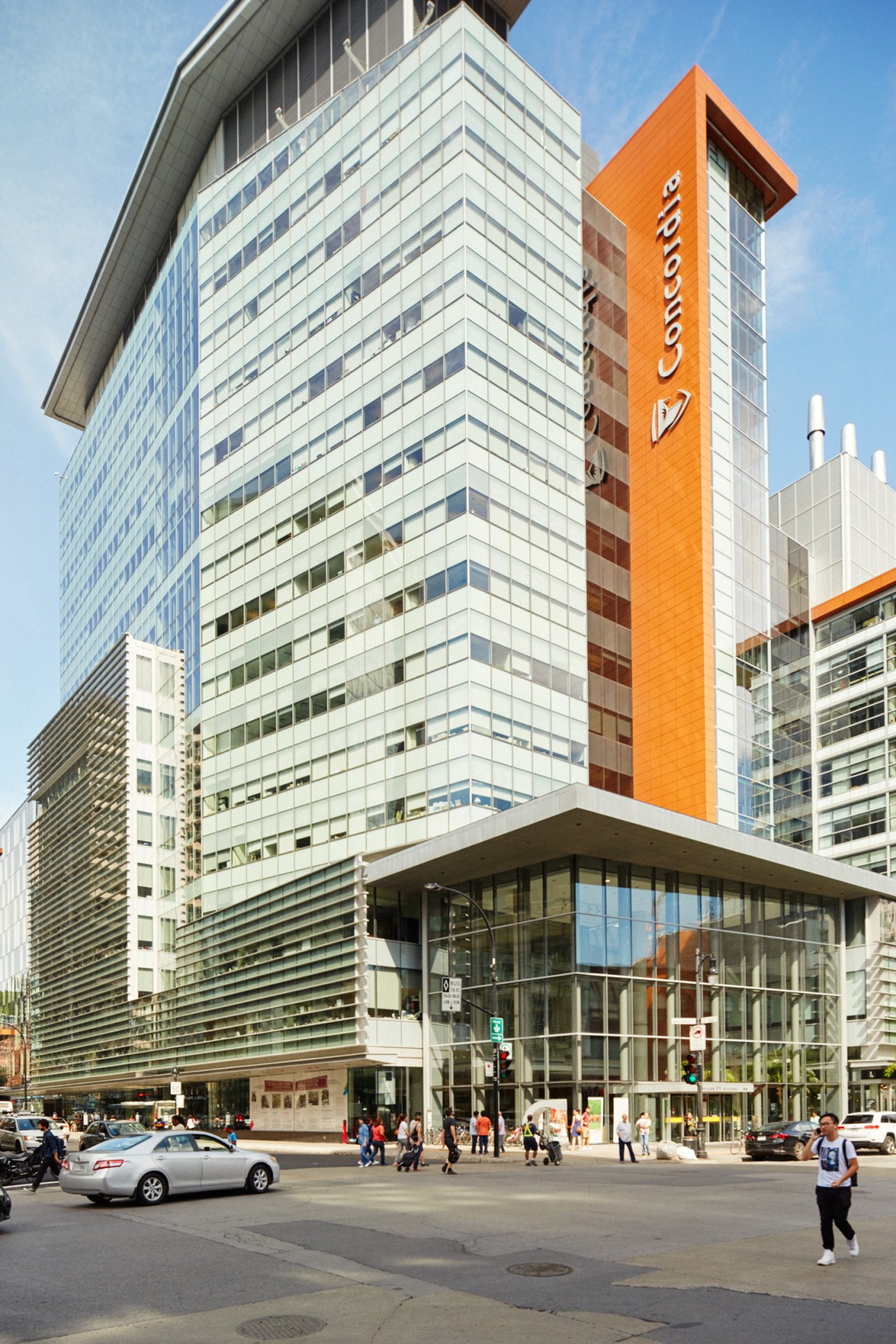 Modern glass and orange concrete Concordia University building with geometric facade and street-level entrance