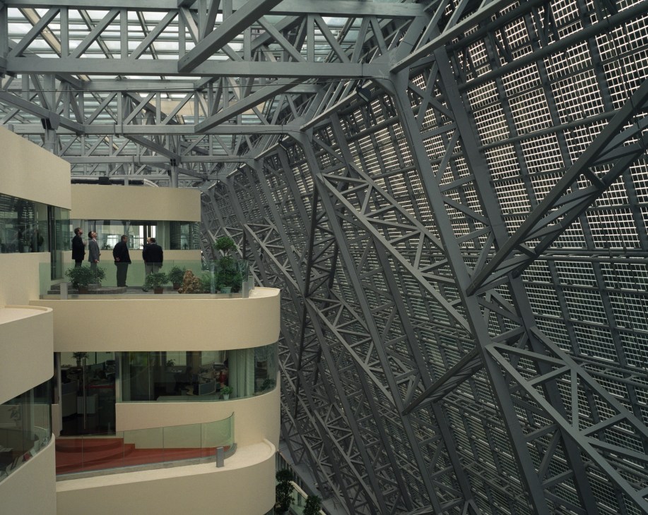 Interior courtyard of Suntech with solar panels on metal framework and curved building with workers visible.