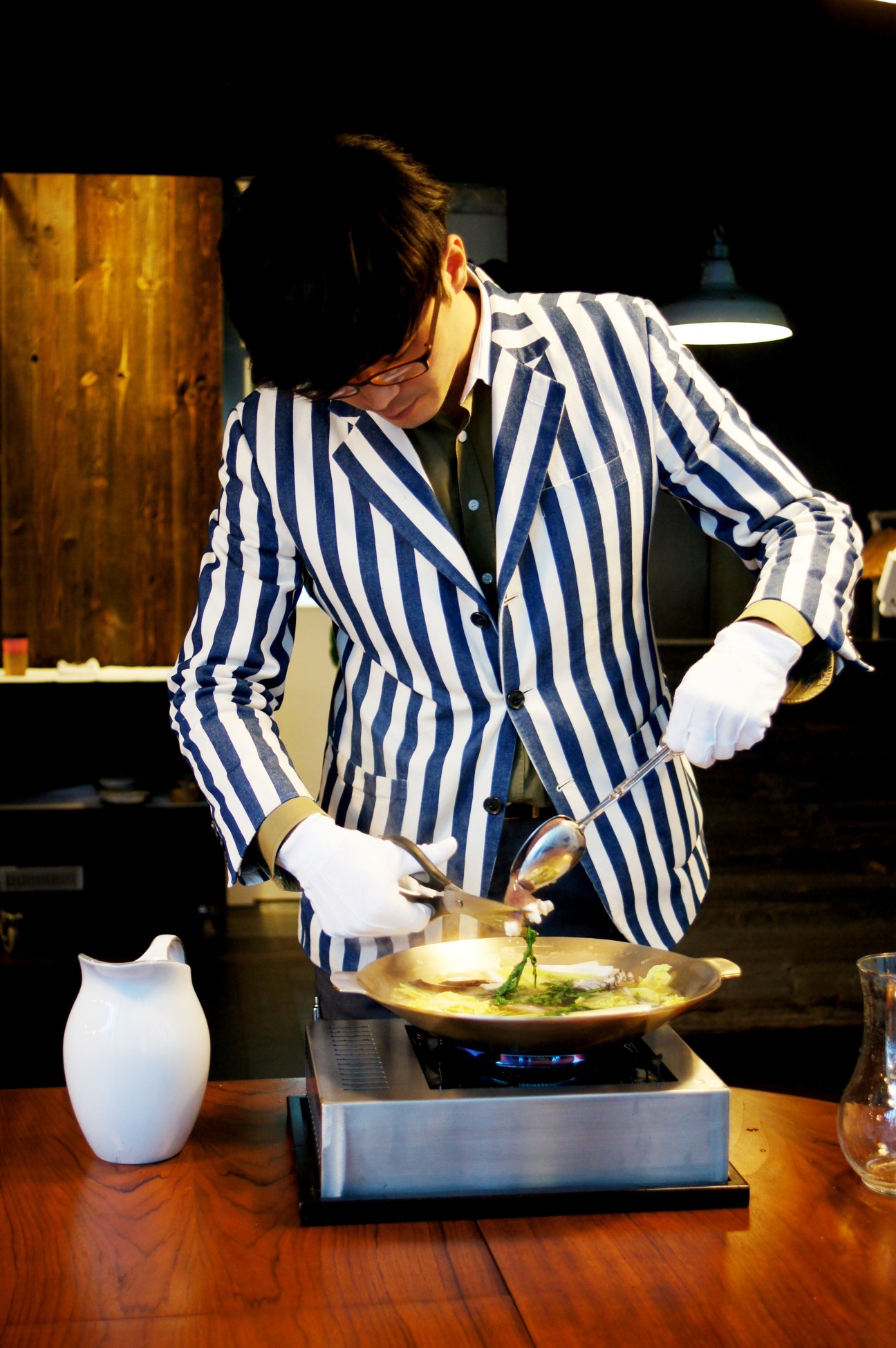 Chef in navy striped blazer and white gloves prepares a dish at O-neul restaurant in Seoul.