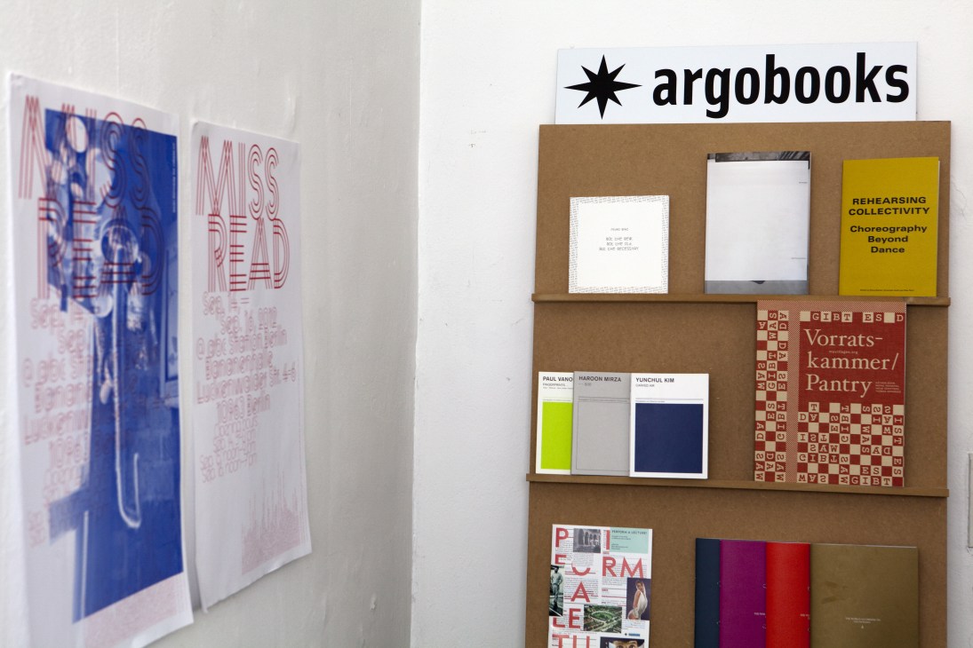 Argobooks display featuring art books on wooden shelves with the argobooks logo and various publications.