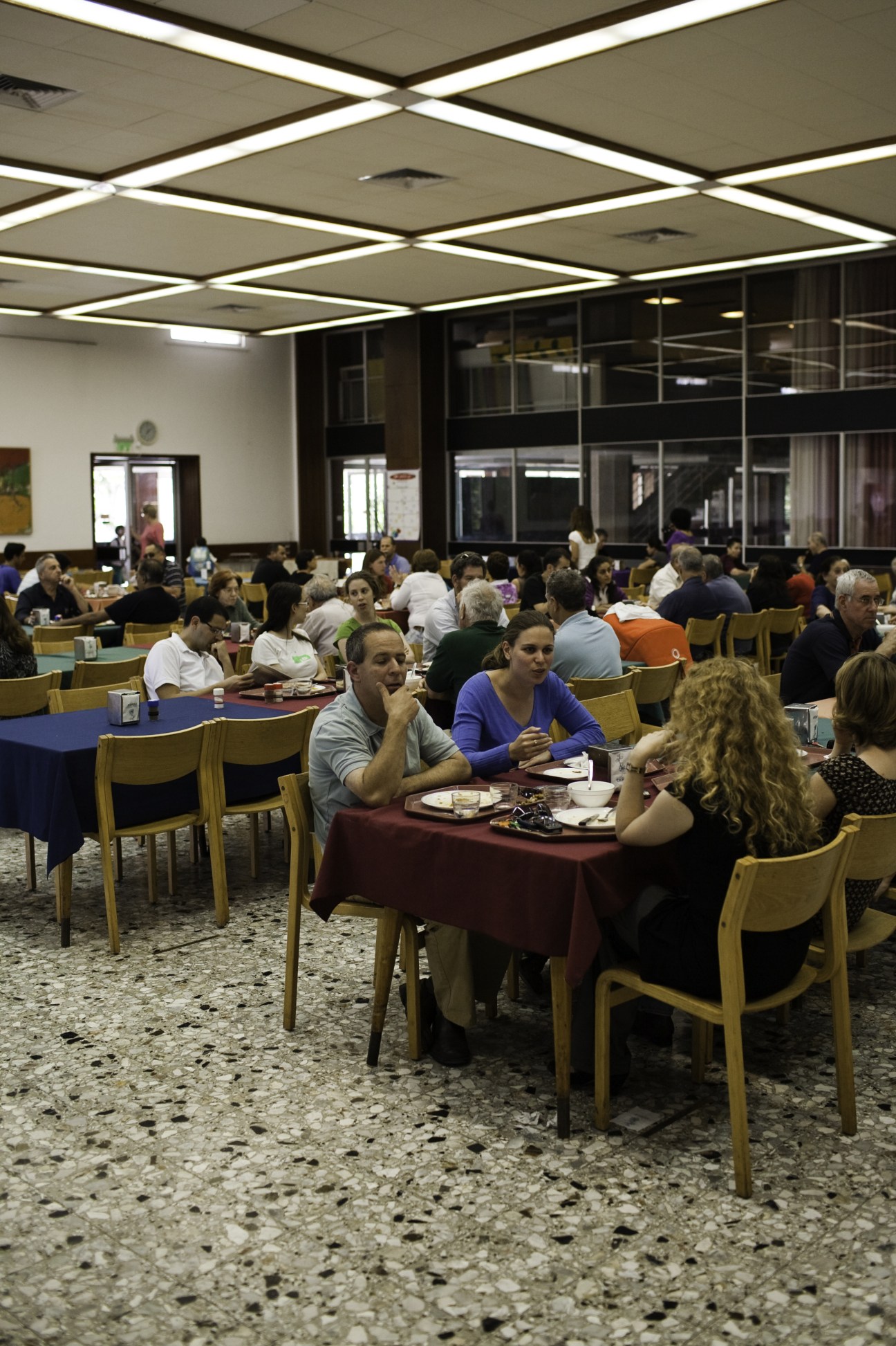 Multiple kibbutz members dining together in a communal dining room at Maabarot kibbutz.