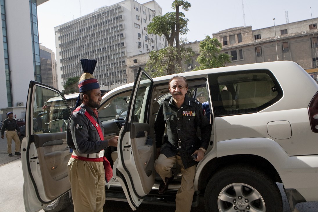 Waseem Ahmed, Karachi's police chief, exits a white vehicle as an officer stands nearby in an urban setting.