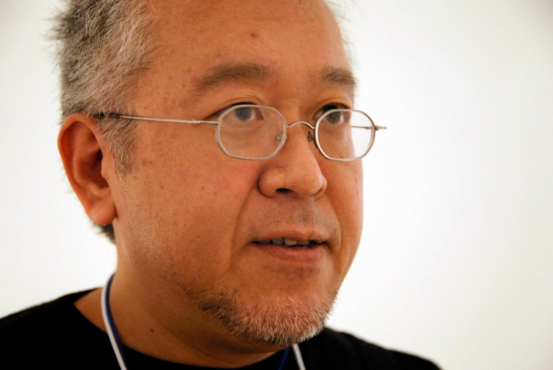 Portrait of Kenya Hara, a designer wearing glasses and a dark shirt.