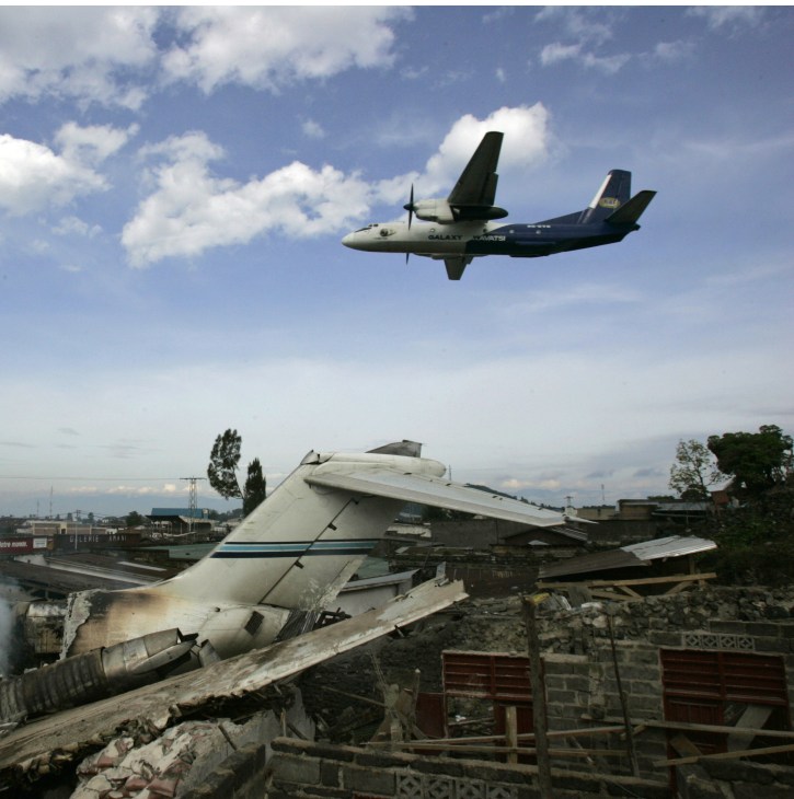 A cargo plane flies over wreckage of a crashed aircraft at Goma airport.