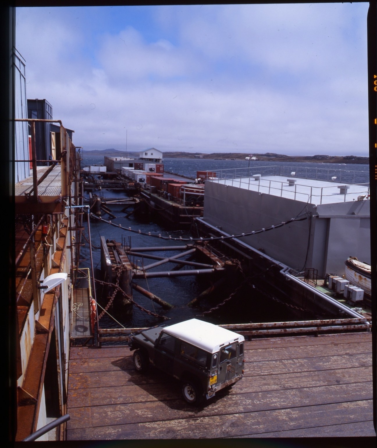 FIPASS port in the Falkland Islands with moored vessels, metal structures, and a Land Rover on the dock.