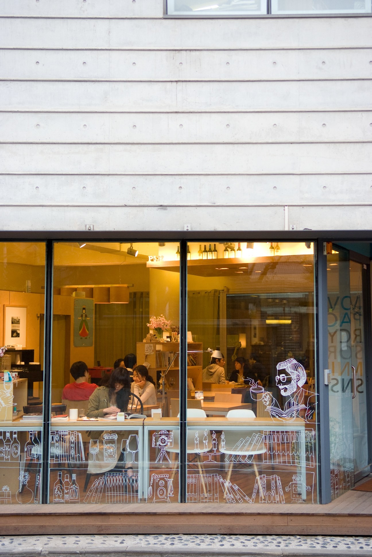 P.532 book café storefront in Seoul with customers inside and illustrated window decals.
