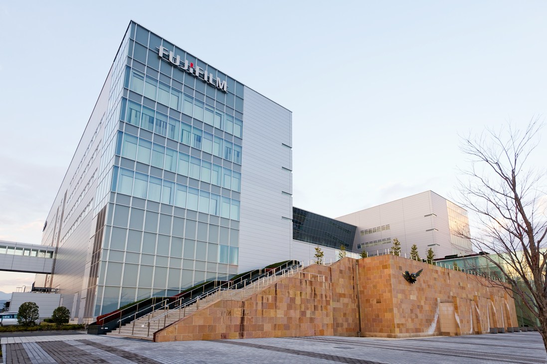 Fujifilm's modern glass and white building with red brick structure at their advanced life science R&D centre in Kaisei, Japan.