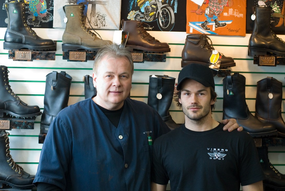 Glen Viberg and his son Brett stand in front of a wall display of Viberg leather boots in their Victoria factory retail store.