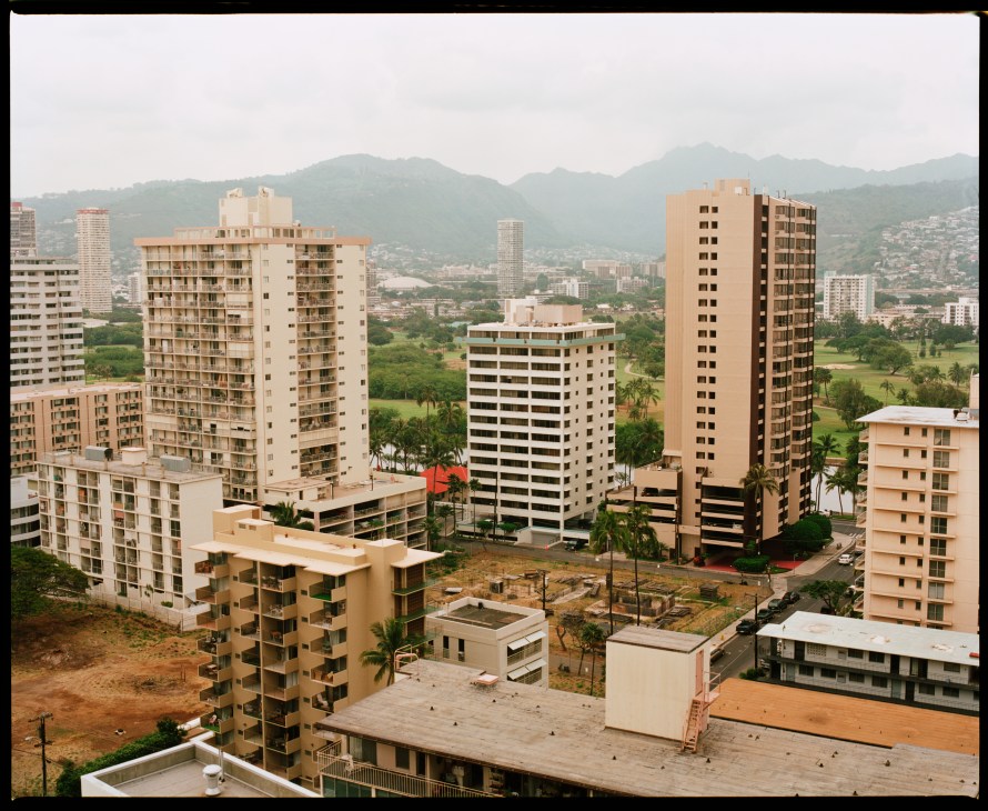 View of Waikiki showing high-rise residential buildings with mountains in the background.