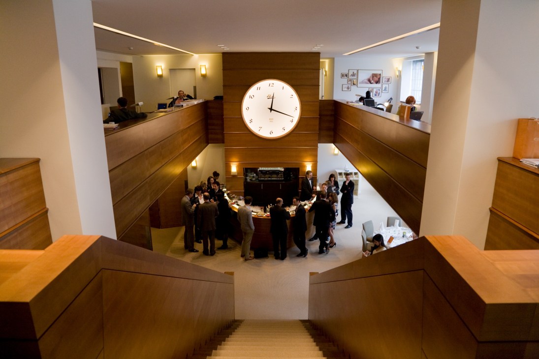 Overhead view of Ebel's bar booth at Baselworld with attendees gathered around illuminated counter displays and a large backlit clock.