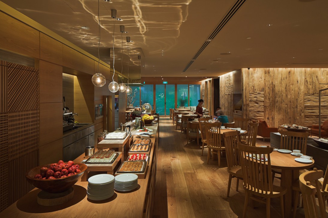 Grand Hyatt Singapore's modern lobby lounge with wooden furnishings, warm lighting, and buffet setup.