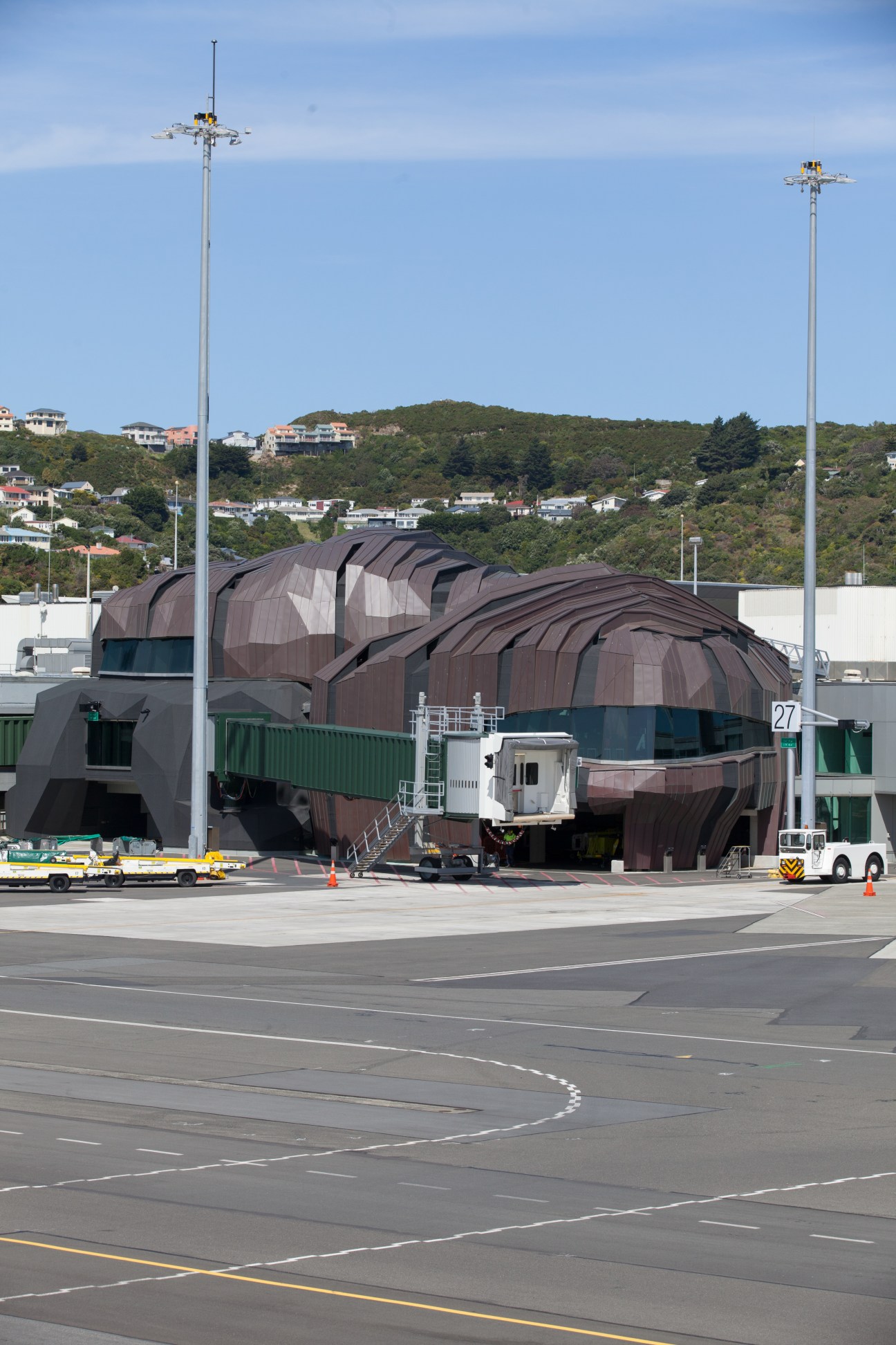Wellington International Airport's copper-clad terminal building with jagged mountain-like architecture on the tarmac.