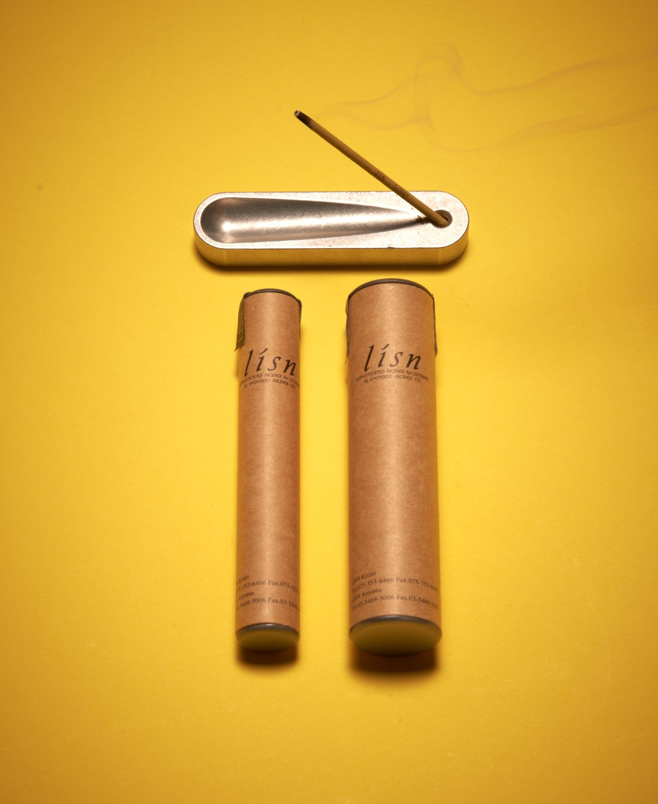 Lisn 'sunny' incense sticks with wooden holder on yellow background.