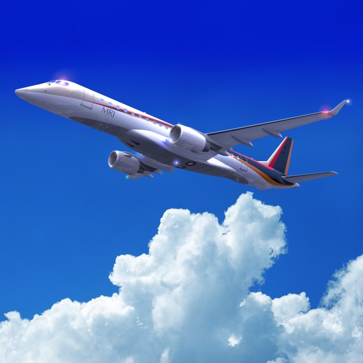 Mitsubishi MRJ regional jet aircraft in flight against blue sky with white clouds