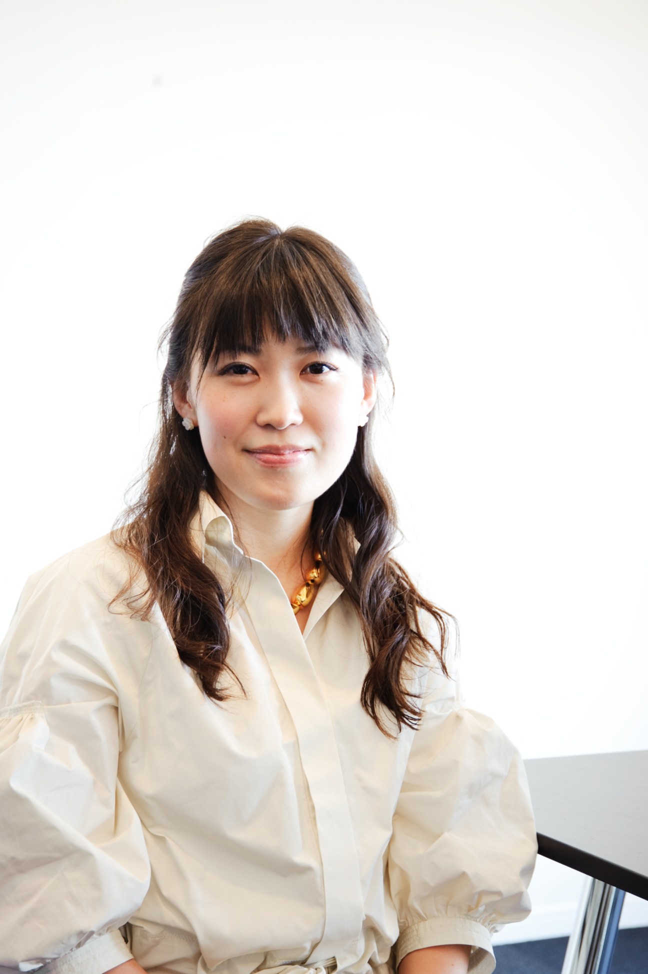 Portrait of Miho Yoshioka, CEO of Clarity Entertainment, wearing a cream-colored shirt against a white background.