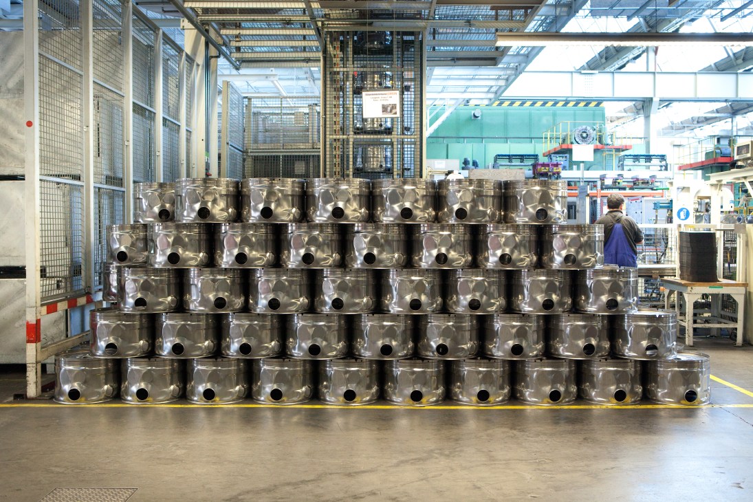 Stacks of metal washing machine drums arranged in the Miele factory ready for assembly.