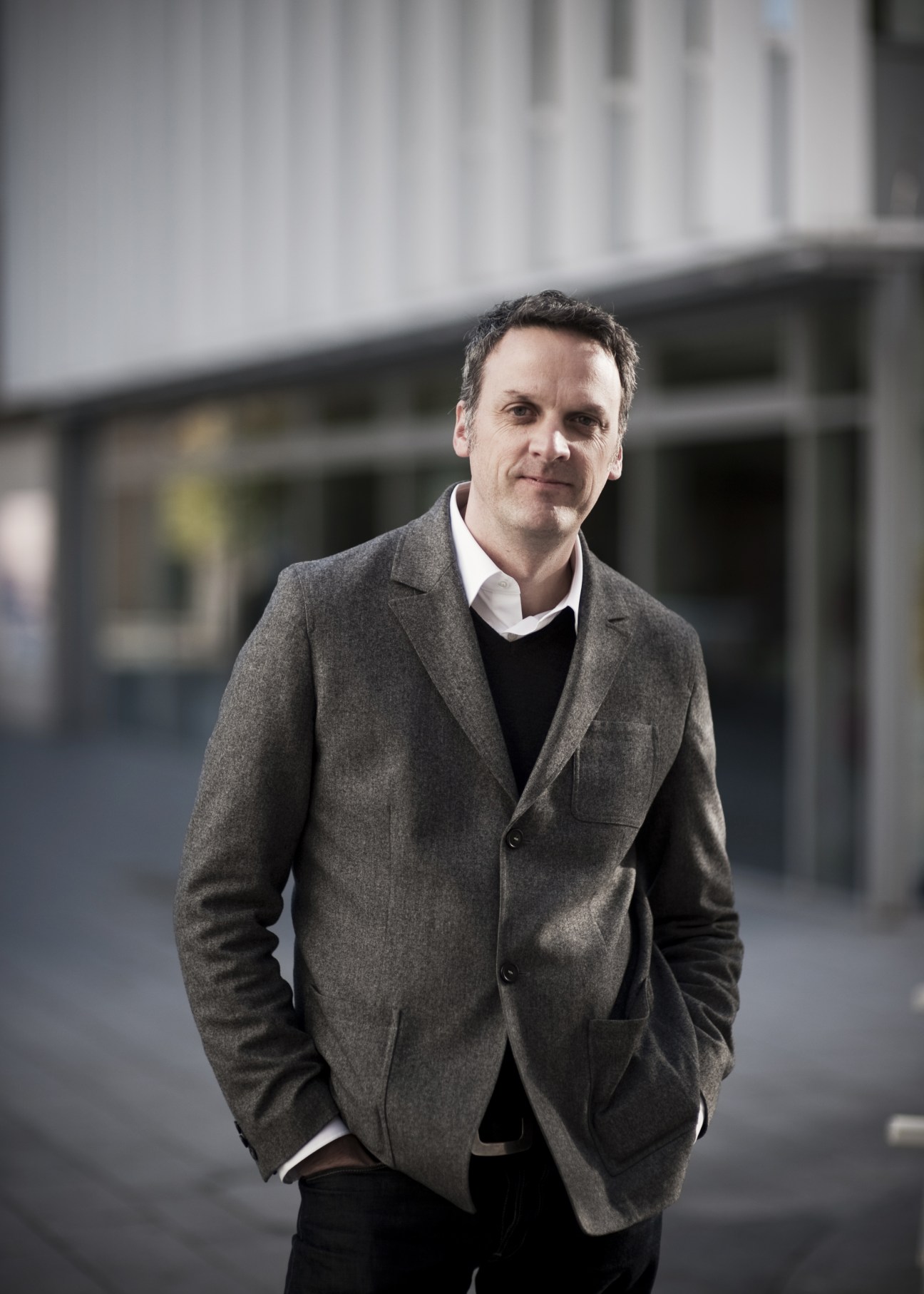 Mark Brearley, head of Design for London, stands outside a modern building wearing a gray blazer.