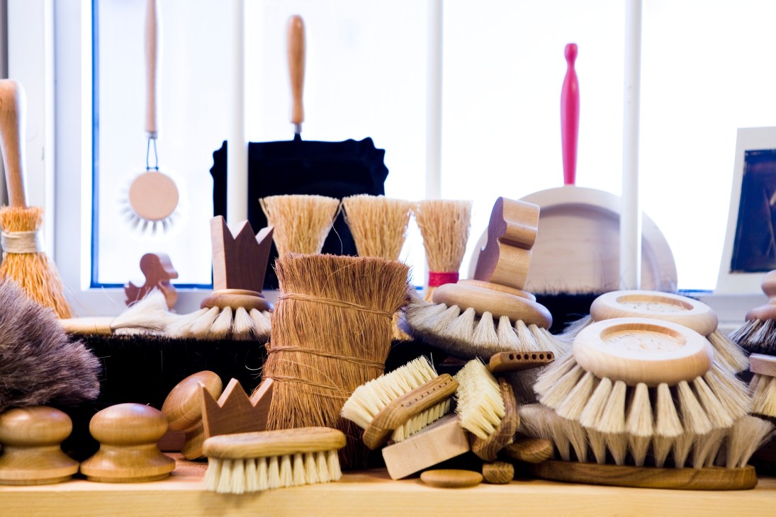 A collection of various handmade Iris Hantverk brushes with wooden handles and natural bristles displayed together.