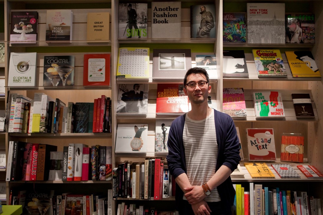 Man standing in front of shelves displaying books and design objects at Clerkenwell Tales bookshop.