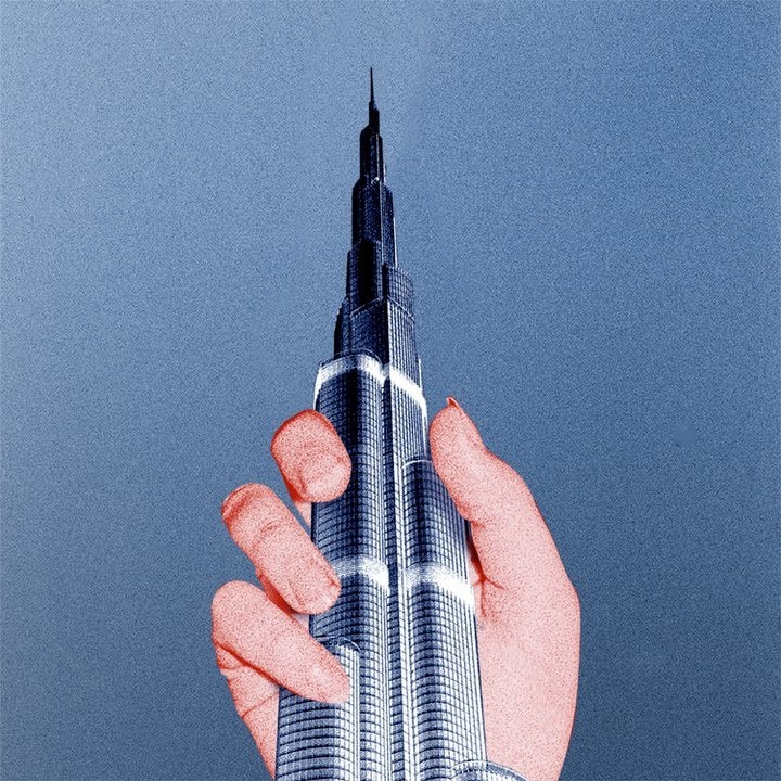 A hand holding the Burj Khalifa skyscraper against a blue sky.
