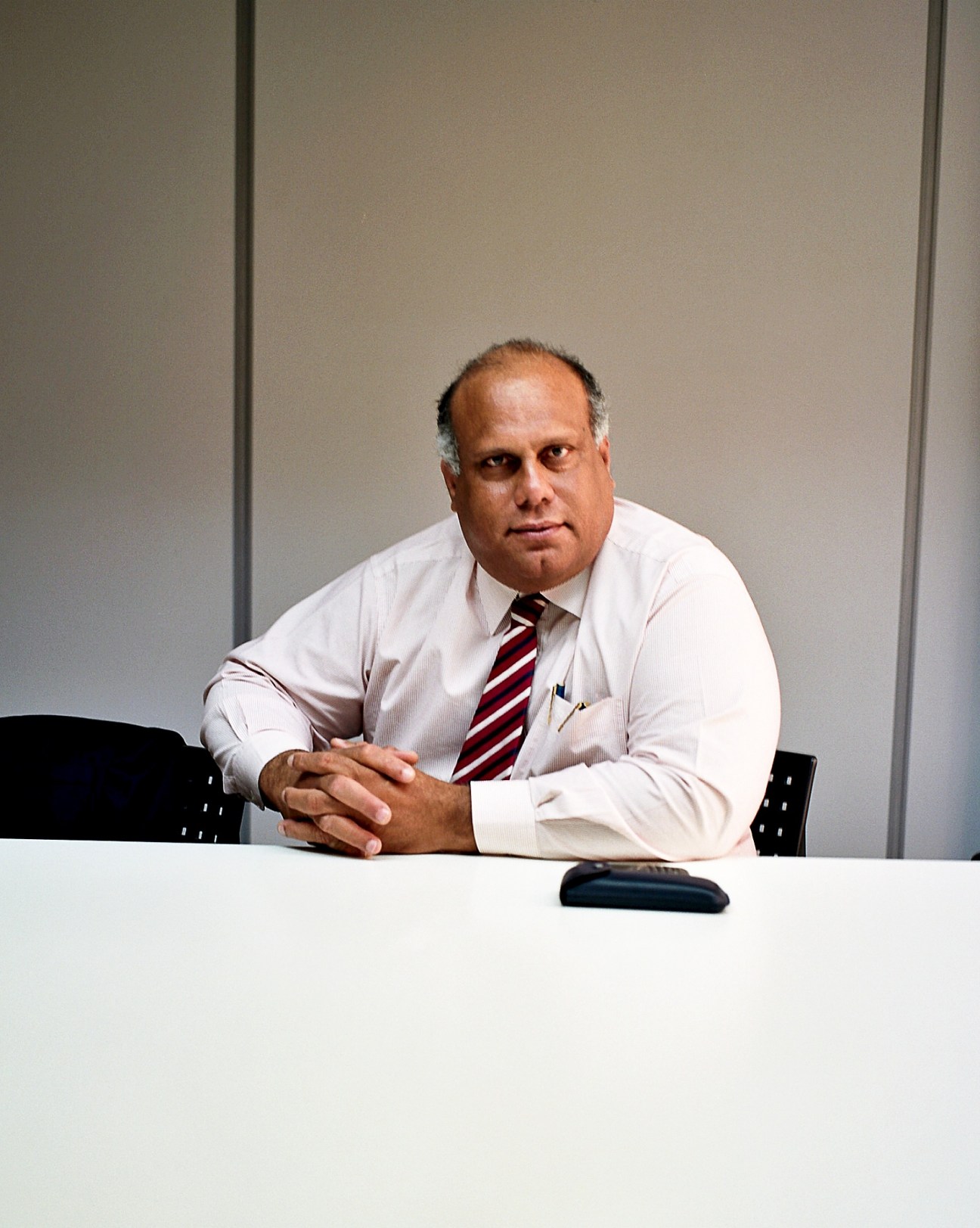 David Dick, economic affairs and tourism commissioner, sits at a white desk wearing a light pink shirt and striped tie.