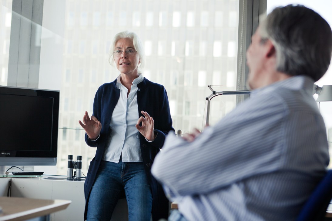 Monika Zucht, cover department designer at Der Spiegel, speaks animatedly in an office with city views.