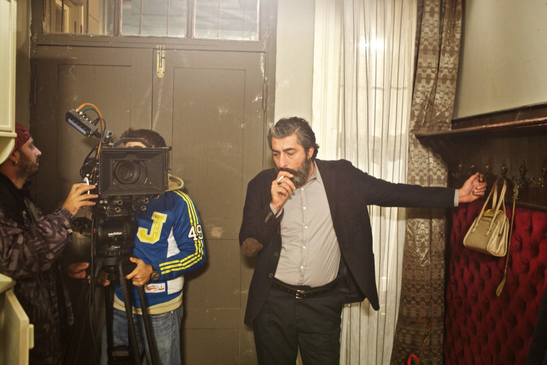 Actor Erkan Petekkaya on set with camera crew during filming of a Turkish drama series.