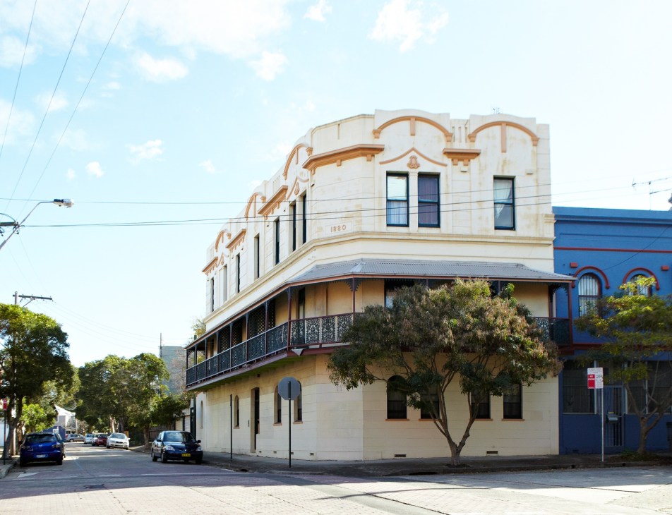 Victorian-era corner building with ornate cream and blue facade on a tree-lined street in Erskineville.